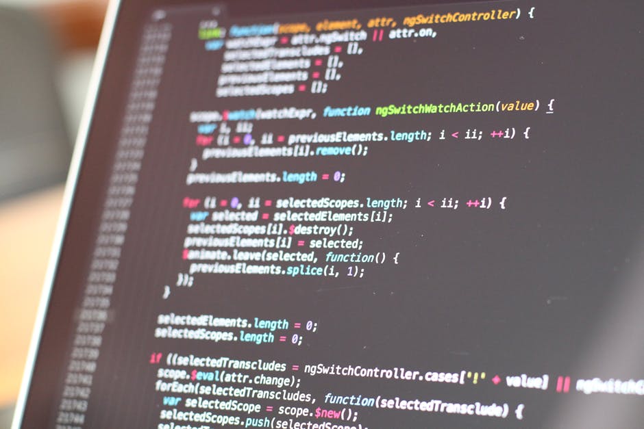 A close-up image of a computer screen displaying colorful lines of programming code in various colors including red, green, yellow, blue, and white, with a blurred background. The code features syntax